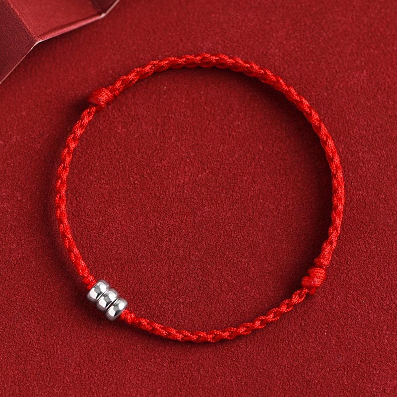 Red braided lucky bracelet with three sterling silver cylindrical charms, centered design