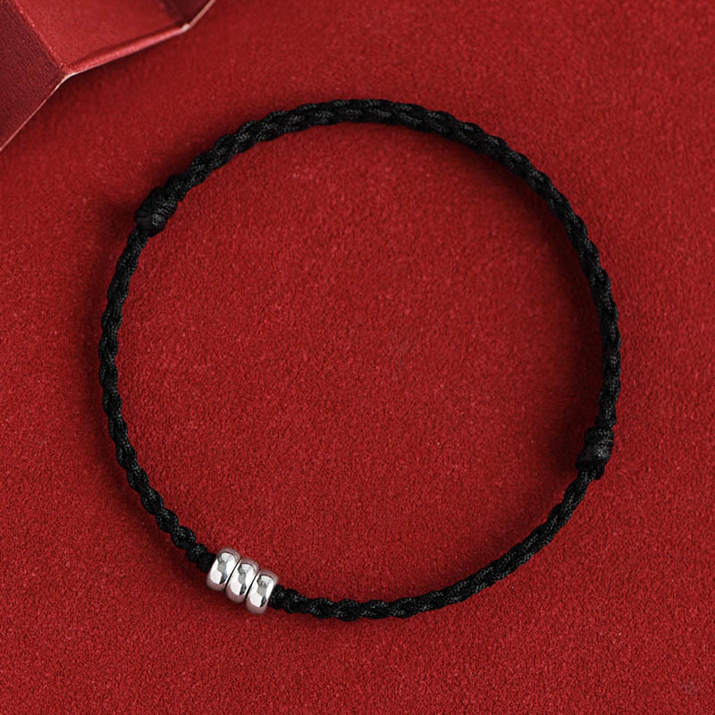Black braided protection bracelet with sterling silver beads, flat top-down view