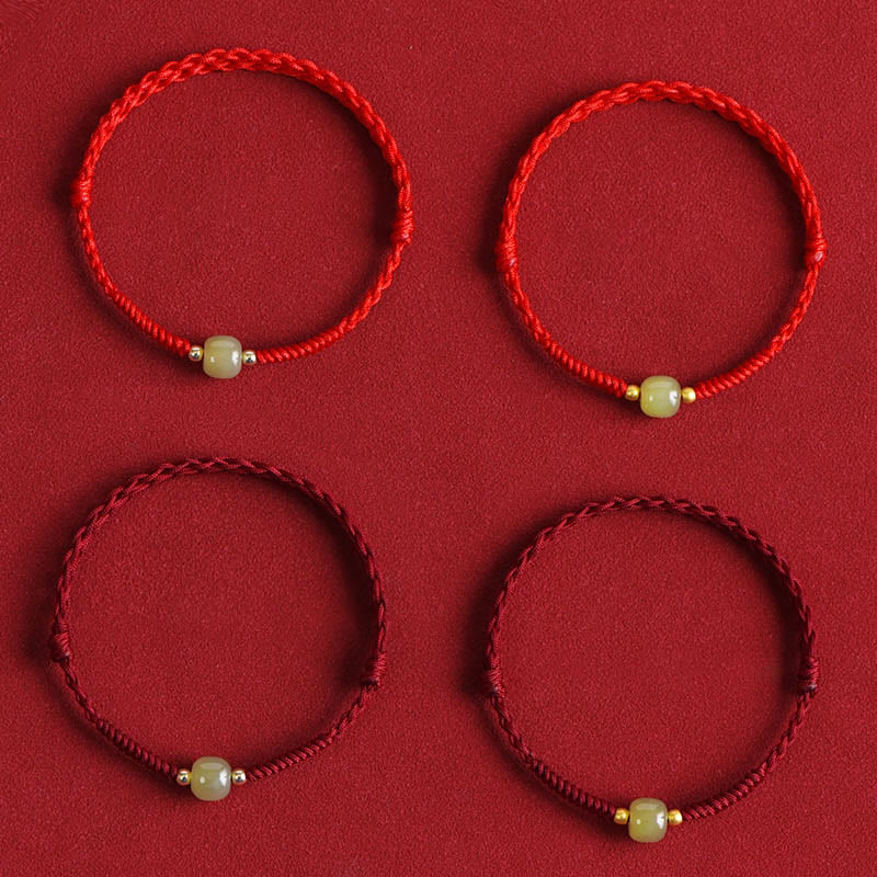 Multiple red jade bracelets collection with gold accents flat lay