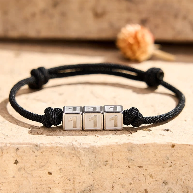 111 angel number manifestation bracelet flat lay with flowers background