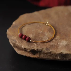 14K gold plated natural cinnabar braided bracelet yellow cord 3 beads view