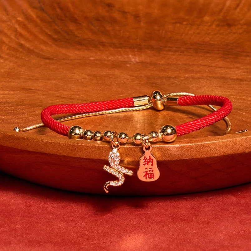 2025 Year of the Snake Fu character red string bracelet main view on wooden tray red fabric background