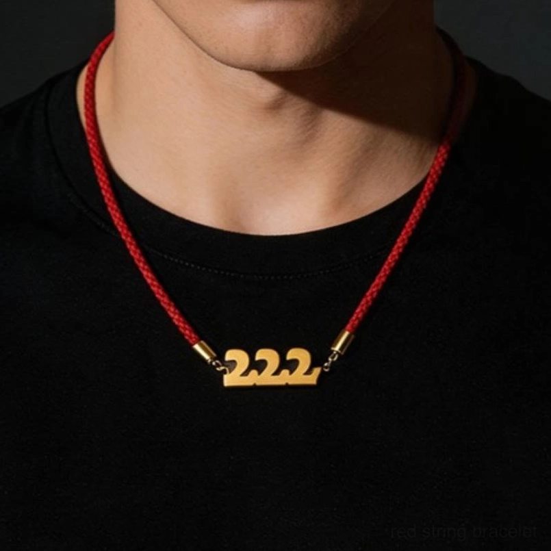 Red string bracelet with 222 angel number pendant worn on wrist