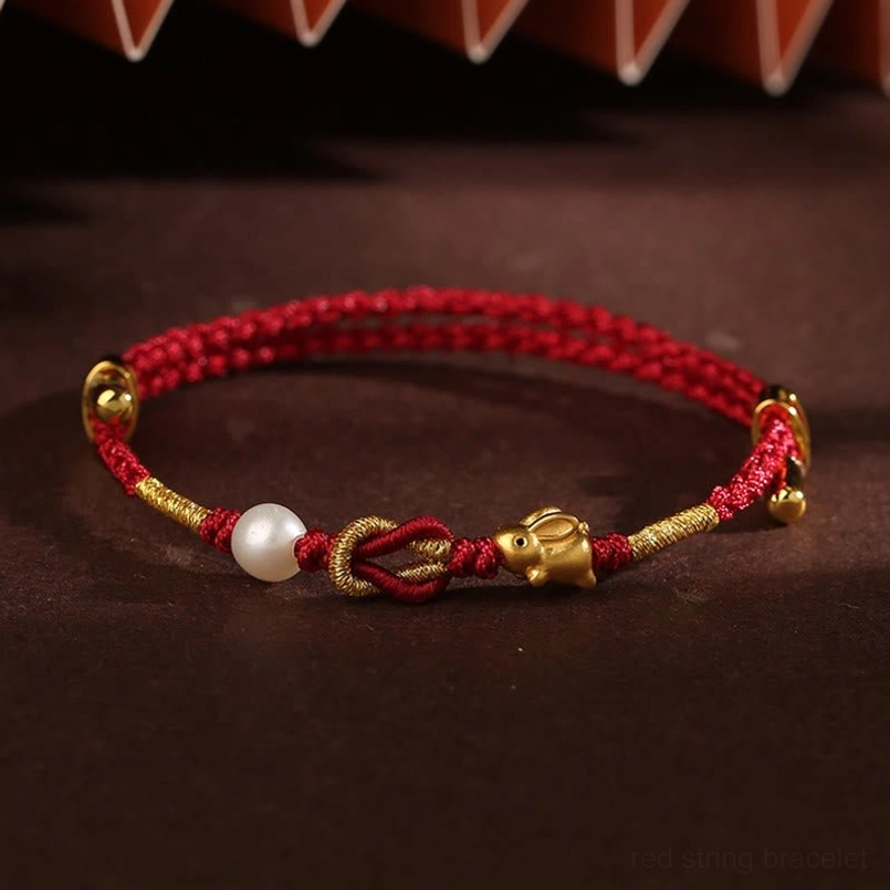 Handcrafted red string bracelet with 24K gold rabbit charm and white pearl detail shot