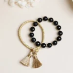2pcs black onyx tassel string bracelet set flat lay on light background