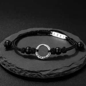 925 sterling silver black onyx peace buckle protection bracelet flat lay on dark slate coaster