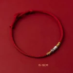 925 sterling silver bamboo red string luck bracelet flat lay on dark red background