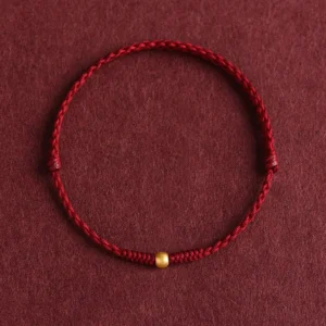 999 gold bead red string braided bracelet flat lay top-down view