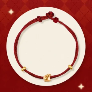 999 gold lucky rabbit red string bracelet flat lay on red diamond backdrop