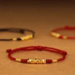 999 gold red string protection bracelet overhead flat lay multiple beads