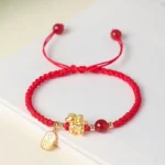 999 sterling silver year of the horse red string bracelet flat lay on white table