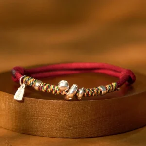 999 Sterling Silver Year of Snake Red String Bracelet main view on wooden round base