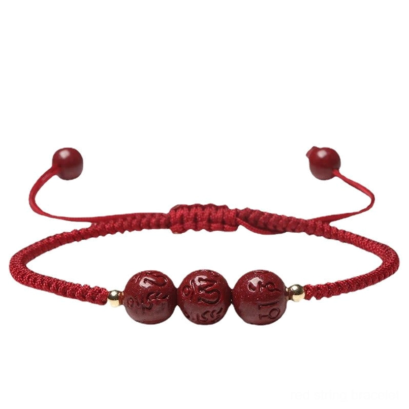 Adjustable cinnabar blessing bracelet with pull-tight knot ends flat lay view