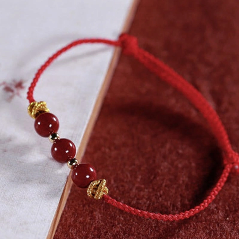 Adjustable cinnabar bracelet oblique top view with golden spacers