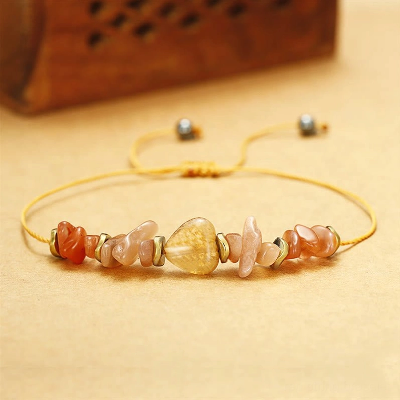Adjustable pull-string red bracelet with copper metal spacers top-down view