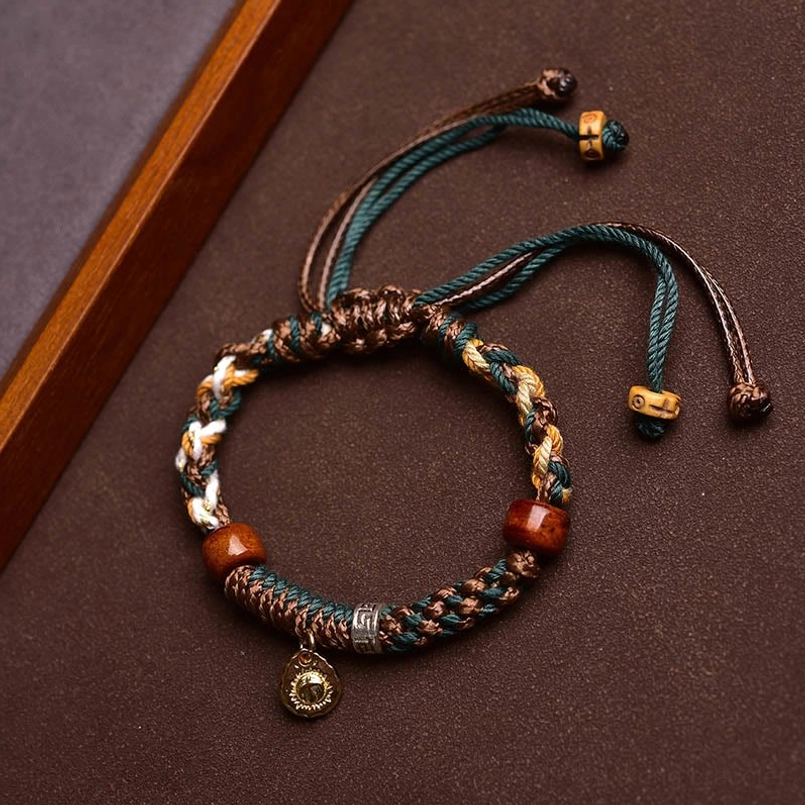 Adjustable drawstring closure detail of handmade Tibetan red string bracelet