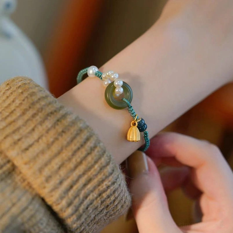 Hand adjusting hetian jade peace buckle bracelet cord on knitted sweater cuff