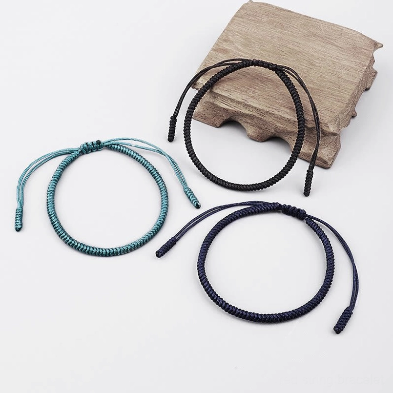 Tibetan protection bracelet with adjustable knot display on wooden block