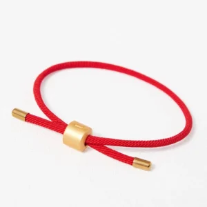 Adjustable lucky red string bracelet matte gold clasp white background