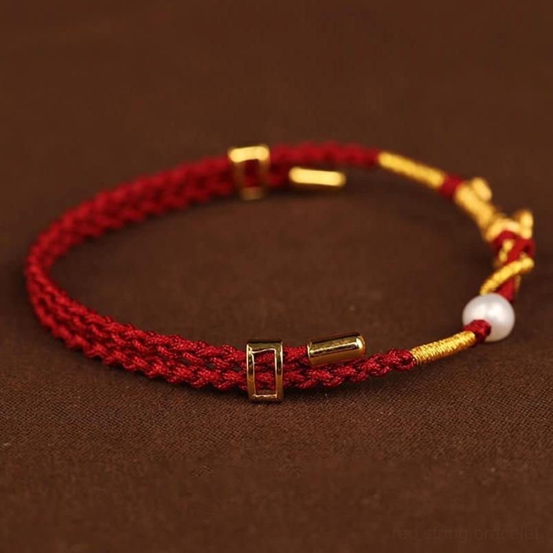 Adjustable red and gold weave bracelet with pearl and metal sliding clasps top-down view