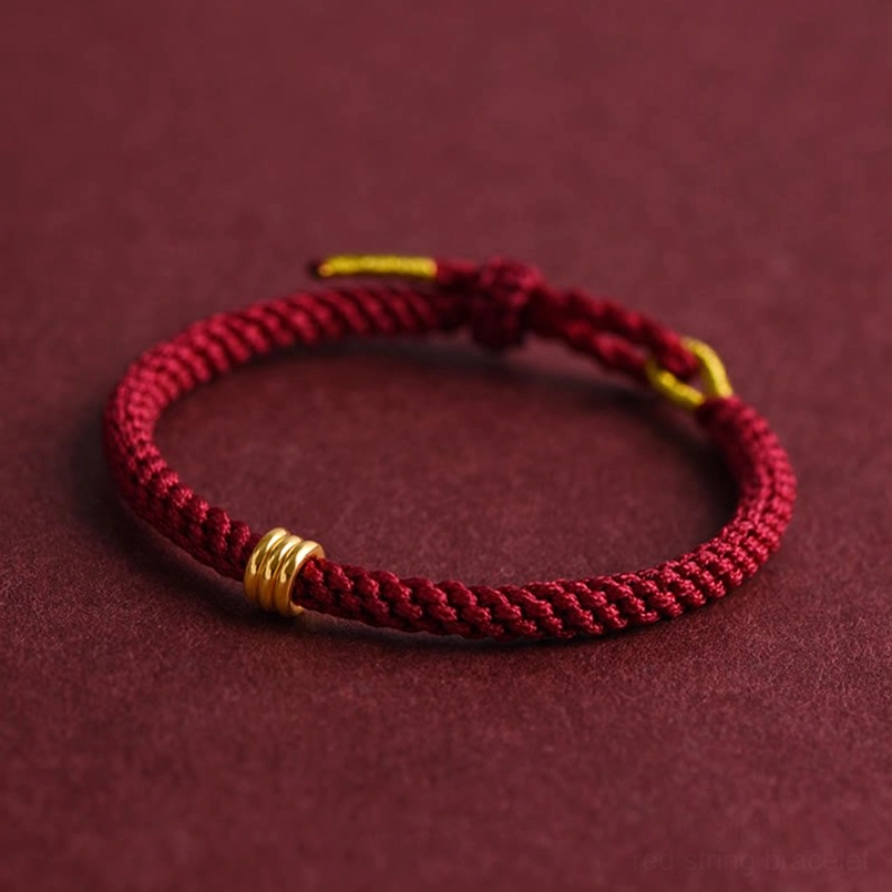 Adjustable red rope bracelet with gold triple ring knotted clasp detail