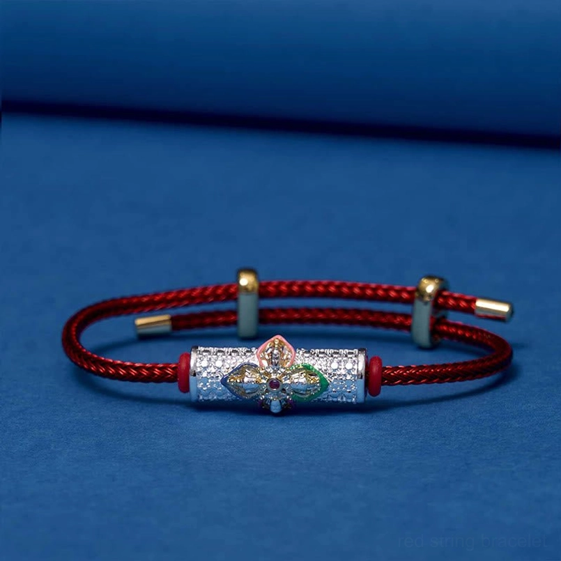 Red string bracelet with adjustable clasp on blue background, showing full closed bracelet design