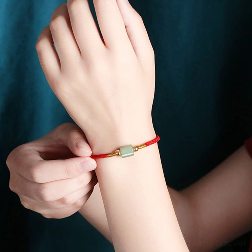 Close-up of adjustable red braided stone bracelet with green aventurine and sliding gold adjuster
