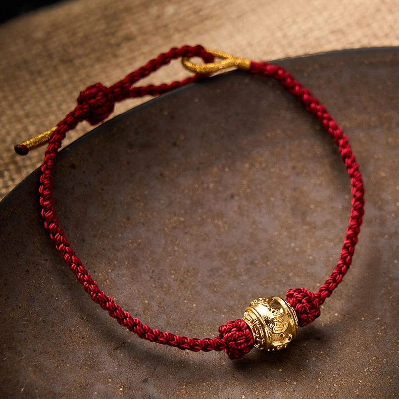 Adjustable red string protection bracelet with engraved copper alloy mantra bead and gold hardware