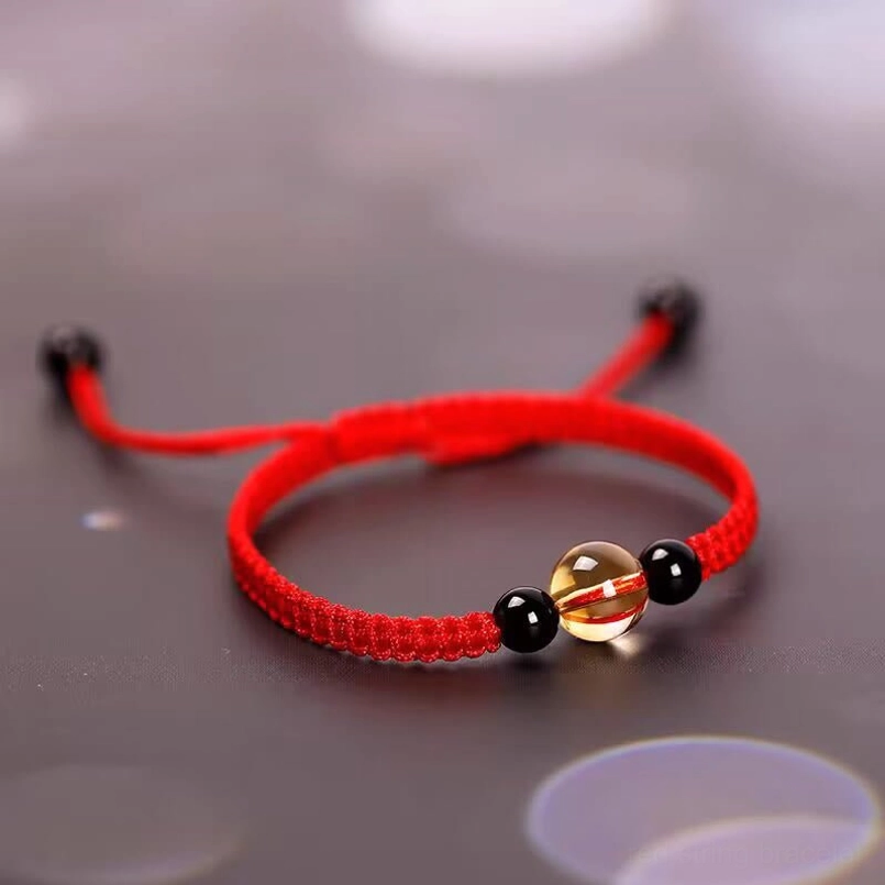 Red string bracelet with adjustable dual pull tight ends low angle view