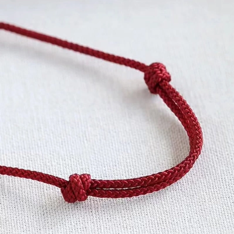Close up of adjustable sliding knot closure on red braided Fu luck bracelet