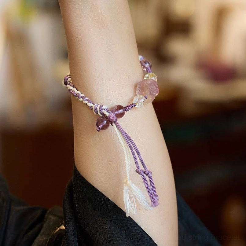 Close up shot of amethyst red string bracelet worn on wrist