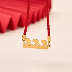 Angel Numbers 222 gold pendant red string bracelet close-up front view