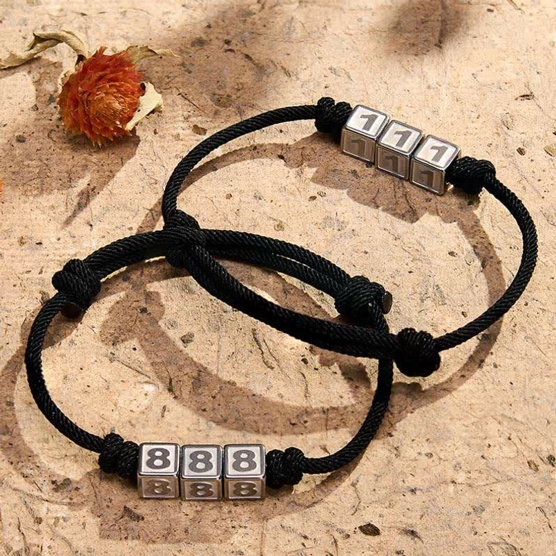 Angel numbers adjustable black string bracelets collection flat lay with dried flowers