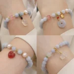 Aquamarine chalcedony charm bracelet with light blue beads and teardrop pendant on wrist, worn with white shirt