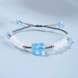 Aquamarine Pixiu Hetian white jade healing bracelet with adjustable knot on light blue background