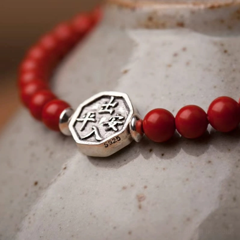 Worn yin yang bagua red cord bracelets on vintage calligraphy paper background