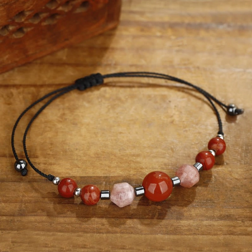 Adjustable red jasper carnelian sunstone bracelet showing sliding knot adjuster on wooden surface