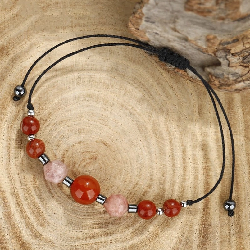 Handcrafted gemstone bracelet on wooden slice showing bead arrangement and adjustable cord
