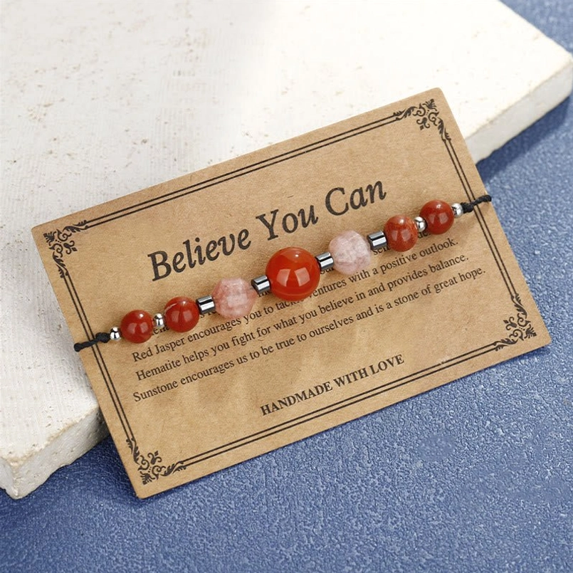 Red jasper carnelian sunstone bracelet with kraft paper card on blue fabric background