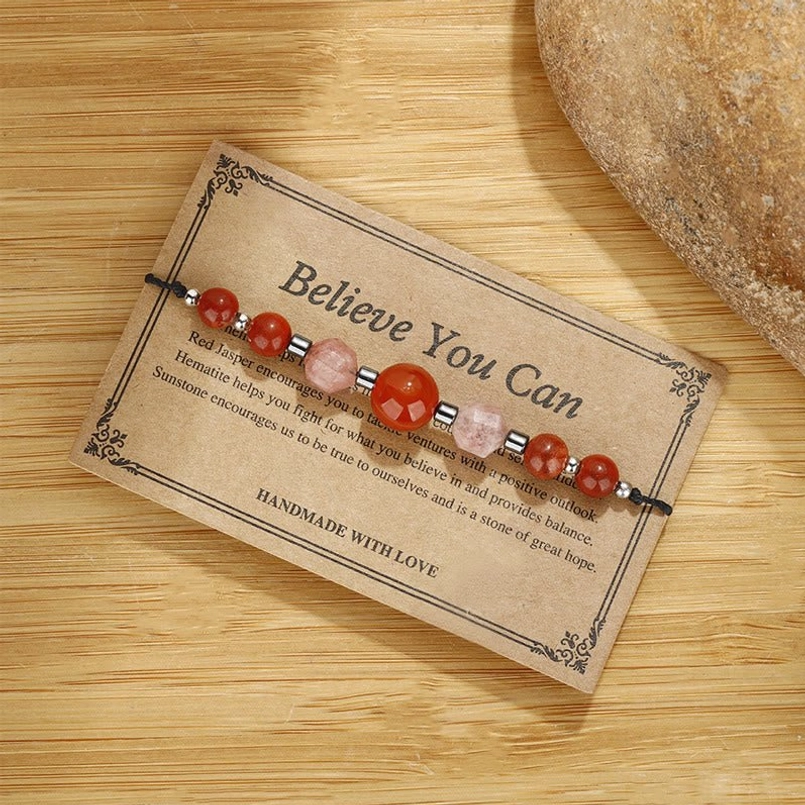 Adjustable gemstone bracelet placed diagonally on display card with decorative stone - flat lay