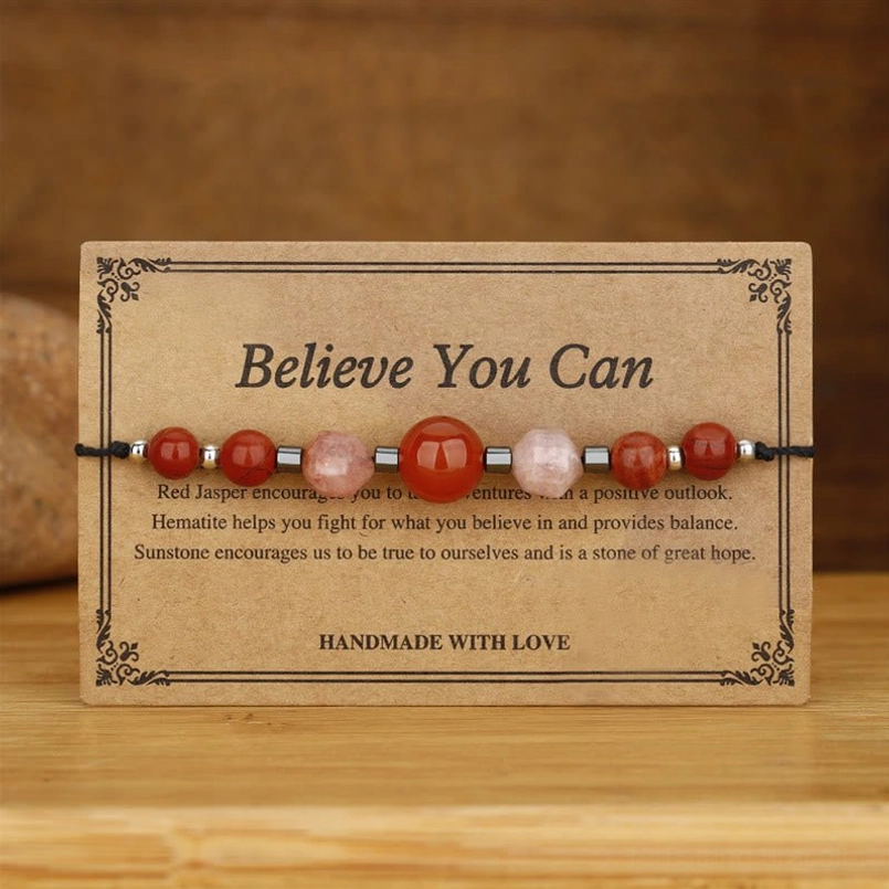 Carnelian sunstone hematite red jasper beaded bracelet on wooden surface - side angle view