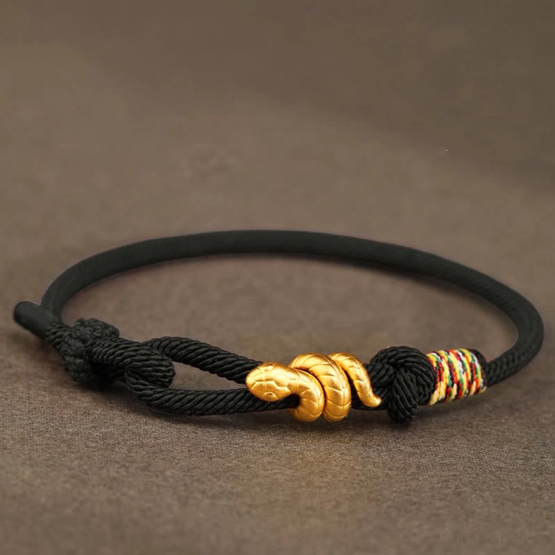 black braided 999 gold snake bracelet full view dark background
