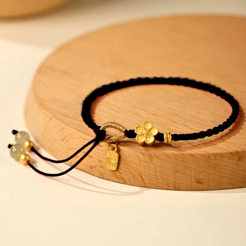 Black braided Hetian jade Fu charm red string bracelet on wooden tray