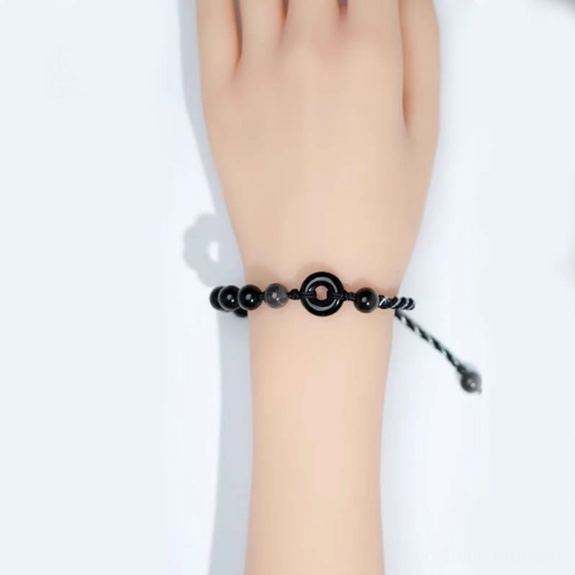 Black obsidian peace buckle bracelet worn on wrist displaying adjustable fit and comfort on mannequin hand