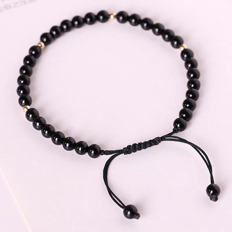 Black obsidian beaded bracelet product shot showing natural stone texture and rope material