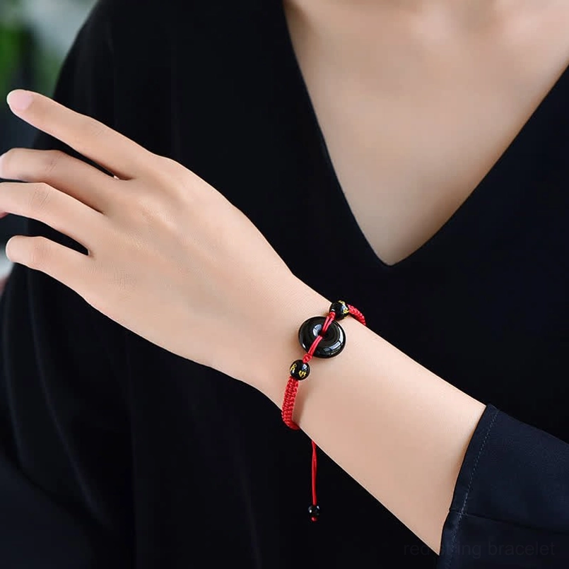 Woman wearing red cord Black Obsidian Peace Buckle bracelet on wrist lifestyle shot