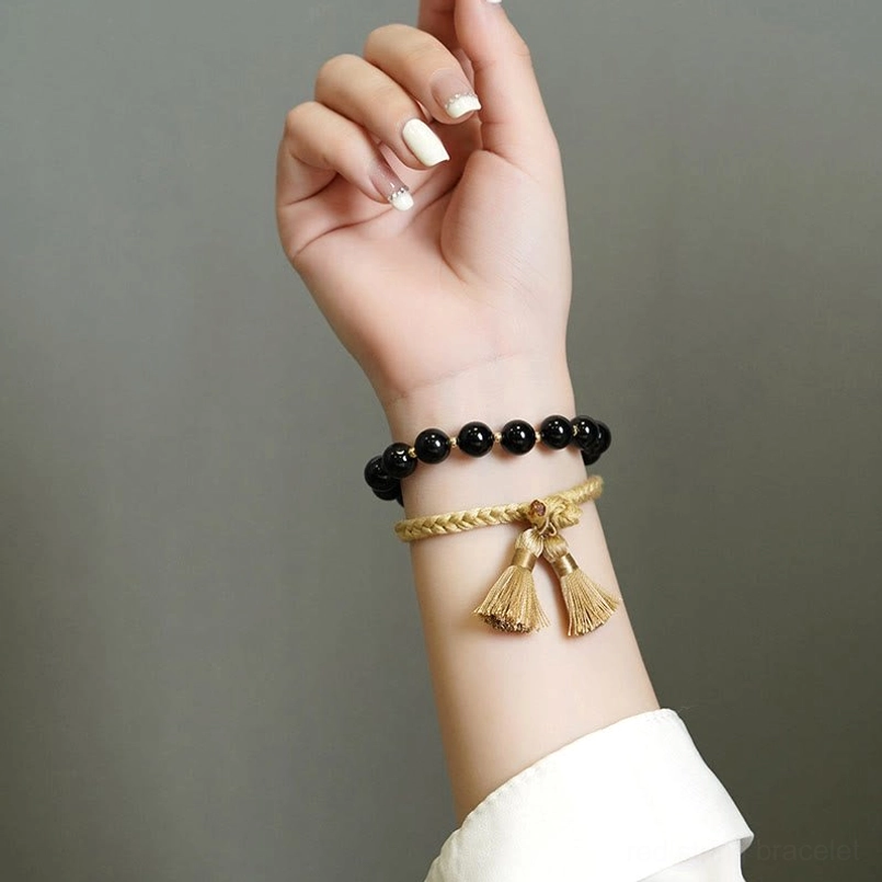 black onyx beaded tassel bracelets worn on wrist with white shirt cuff