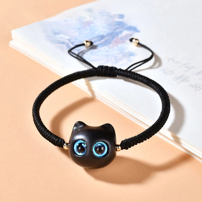 Black rope cat charm bracelet with ebony wood pendant on neutral background