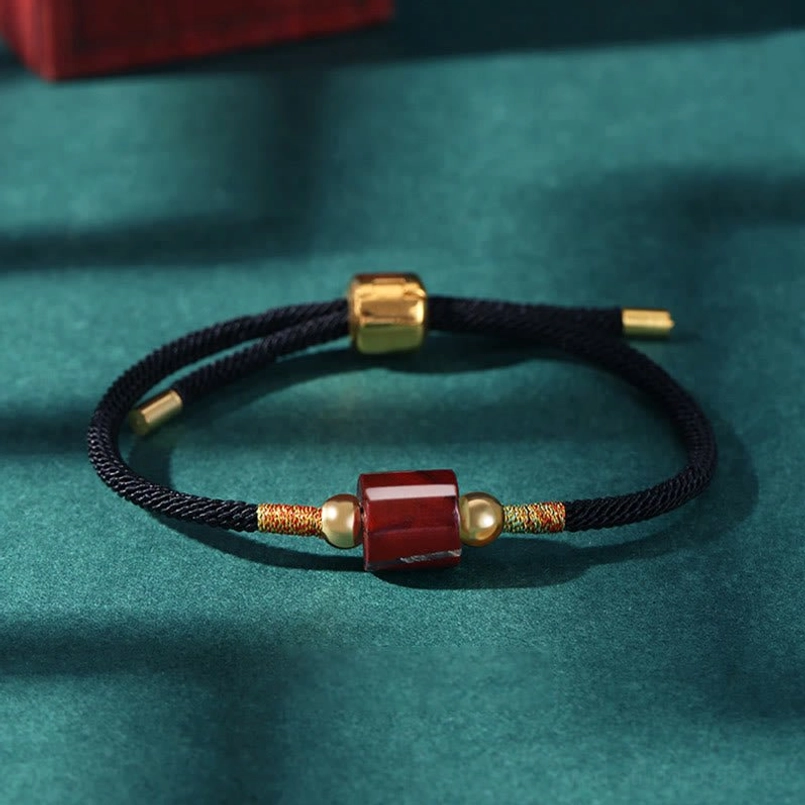 Black rope Tibetan bracelet with red stone bead featuring protective energy and natural materials