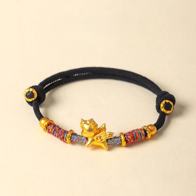 Black braided string bracelet with gold horse charm flat lay